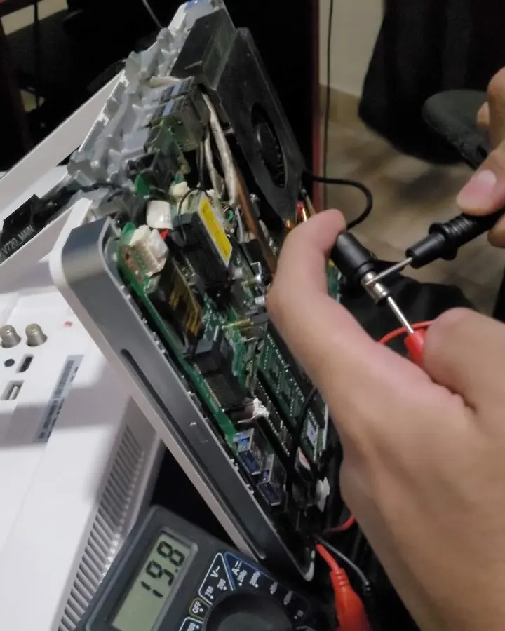 Medição com multímetro em um computador all-in-one aberto na bancada